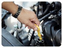 Person checking engine oil with dipstick in car, symbolizing Gulf Way’s reliable service and care