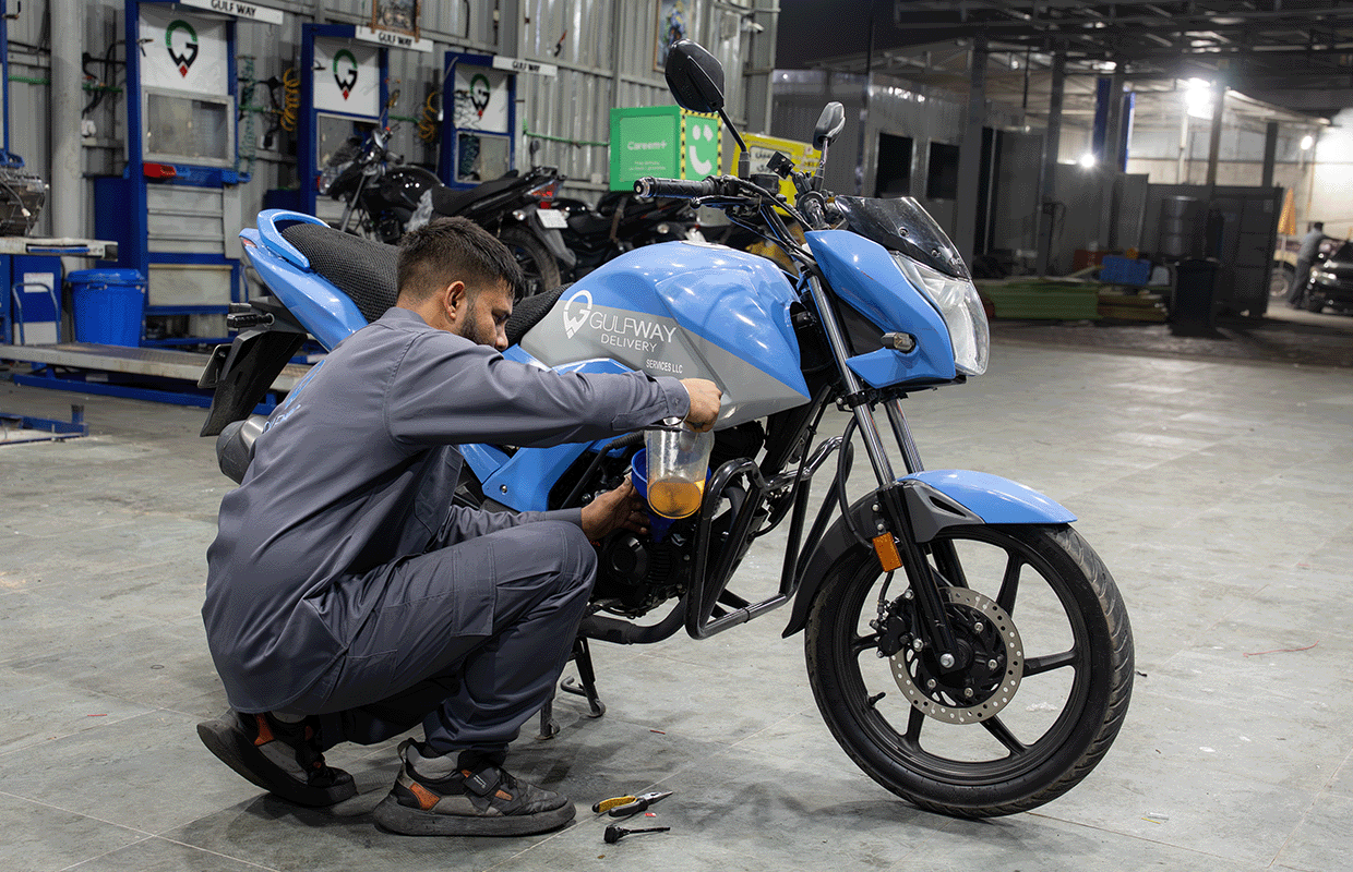 Gulf Way Oil Trading technician performing an oil change on a motorcycle with our quality-assured oil in the in-house garage