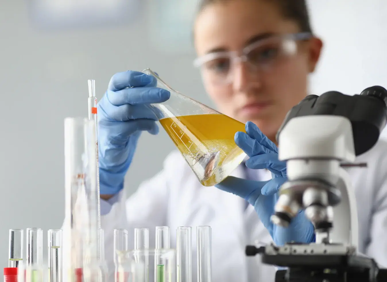 Chemist mixing chemicals in a lab flask representing lubricant innovation